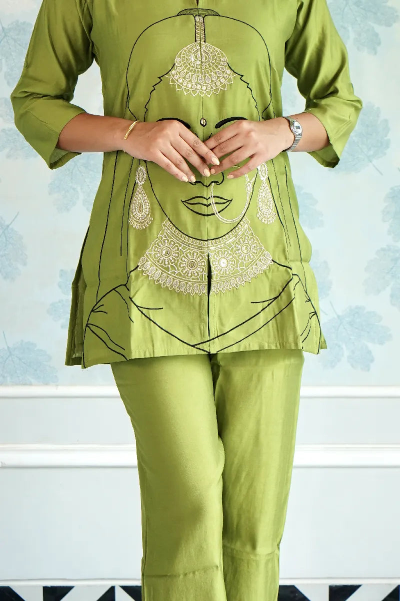 OLIVE GREEN KURTA SET WITH EMBROIDERED WOMAN FACE ART & STATEMENT JEWELRY DETAILING